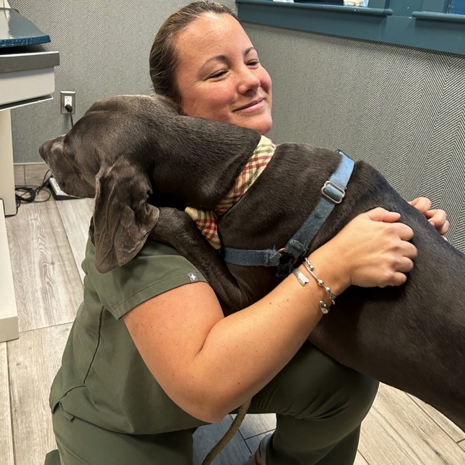 woman hugging gray dog